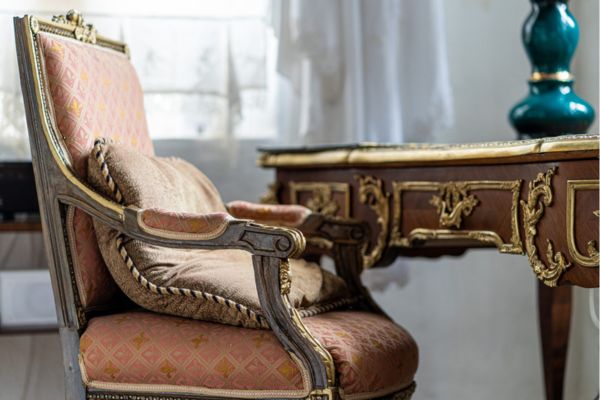 Old antique wooden chair with a pastel-colored cushion