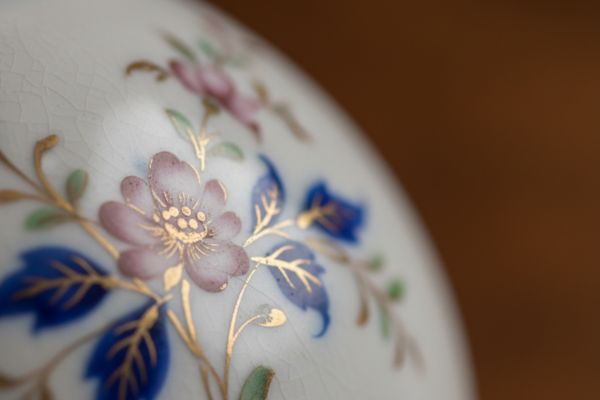 Dettaglio ravvicinato della smaltatura su porcellana antica con superficie leggermente irregolare tipica della lavorazione manuale